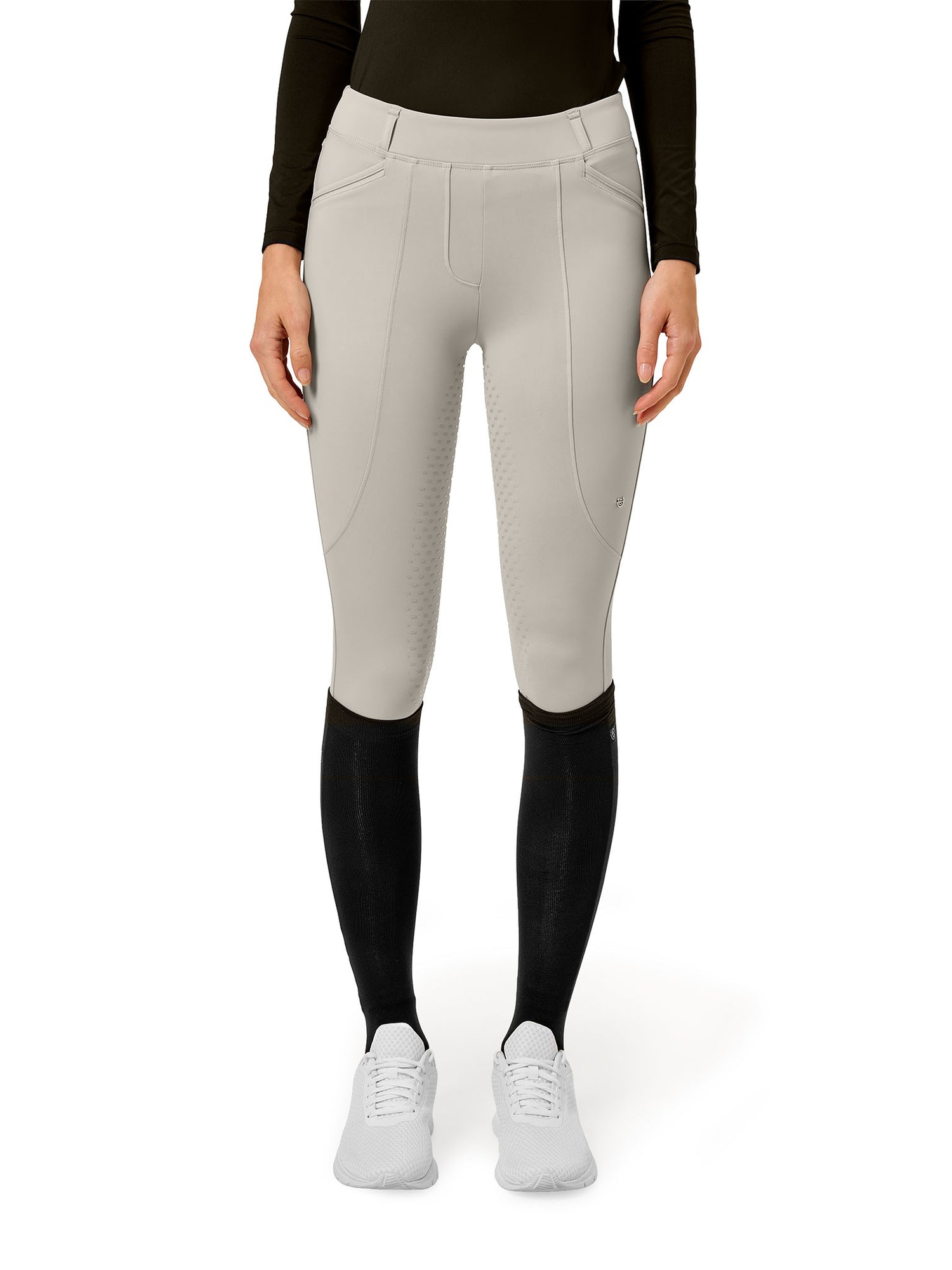 Immagine in studio di Equestrian Stockholm Collant da Equitazione Premium Greige con maglia nera, calzini neri e sneaker bianche.