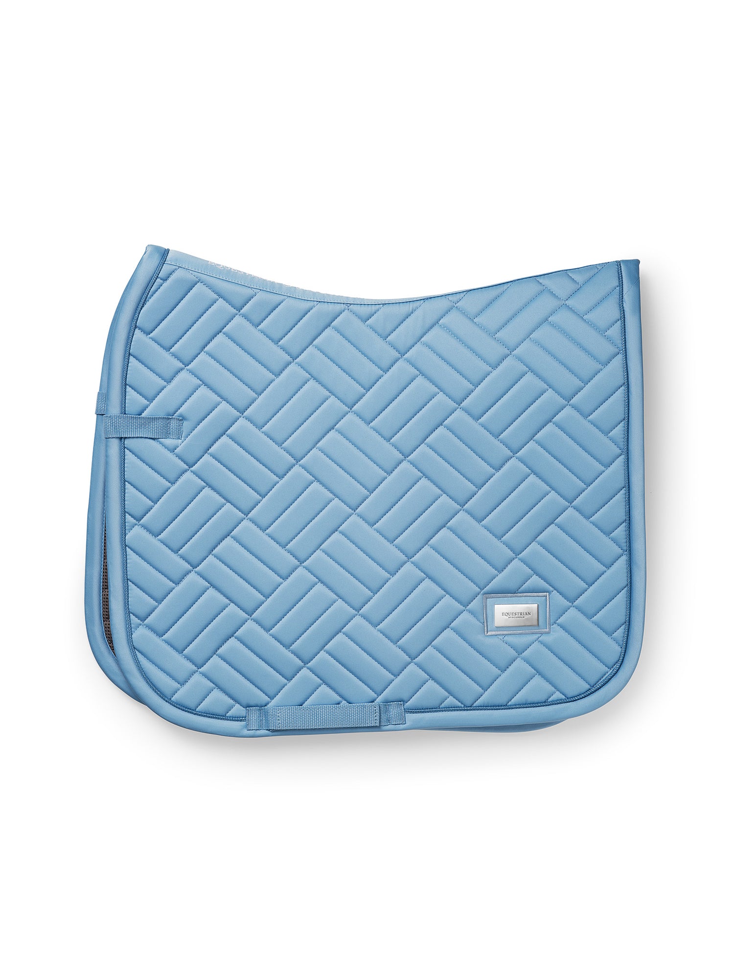 Studiobillede af Equestrian Stockholm dressurunderlag Modern Midsummer Blue med moderne quiltning og sølvbadge.