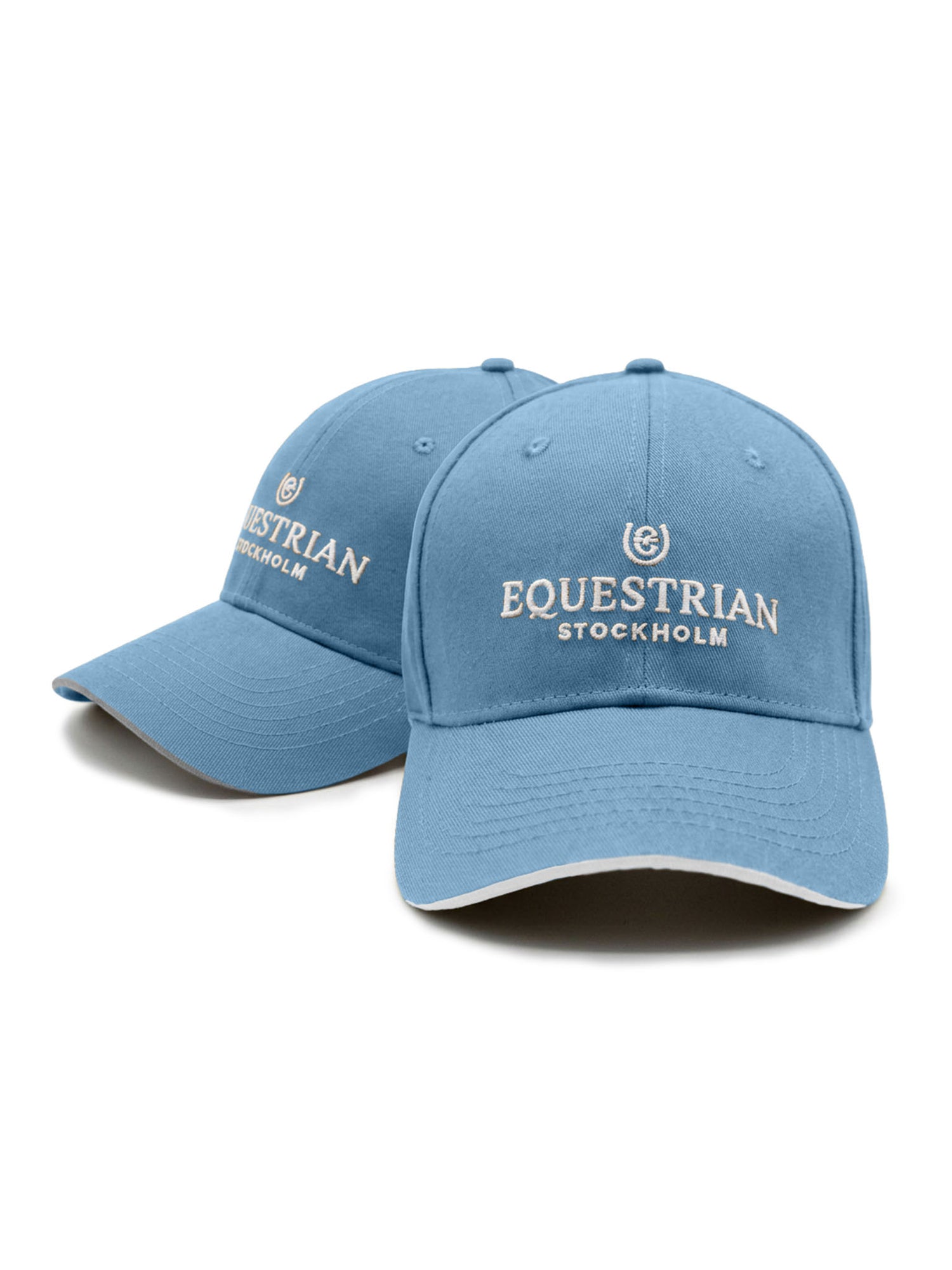 Studio image of two Equestrian Stockholm Cap Soft Blue hats in blue cotton featuring embroidered logos.