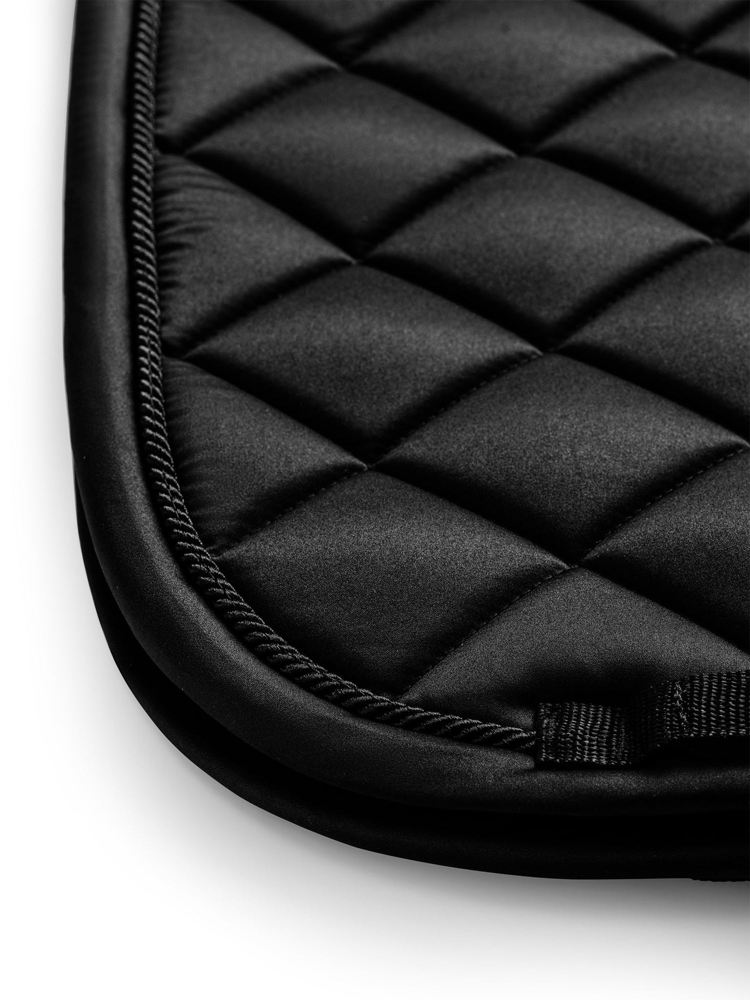 Studiobillede af Equestrian Stockholm dressurunderlag Line Black med firkantet quiltning og tonale kantbånd.