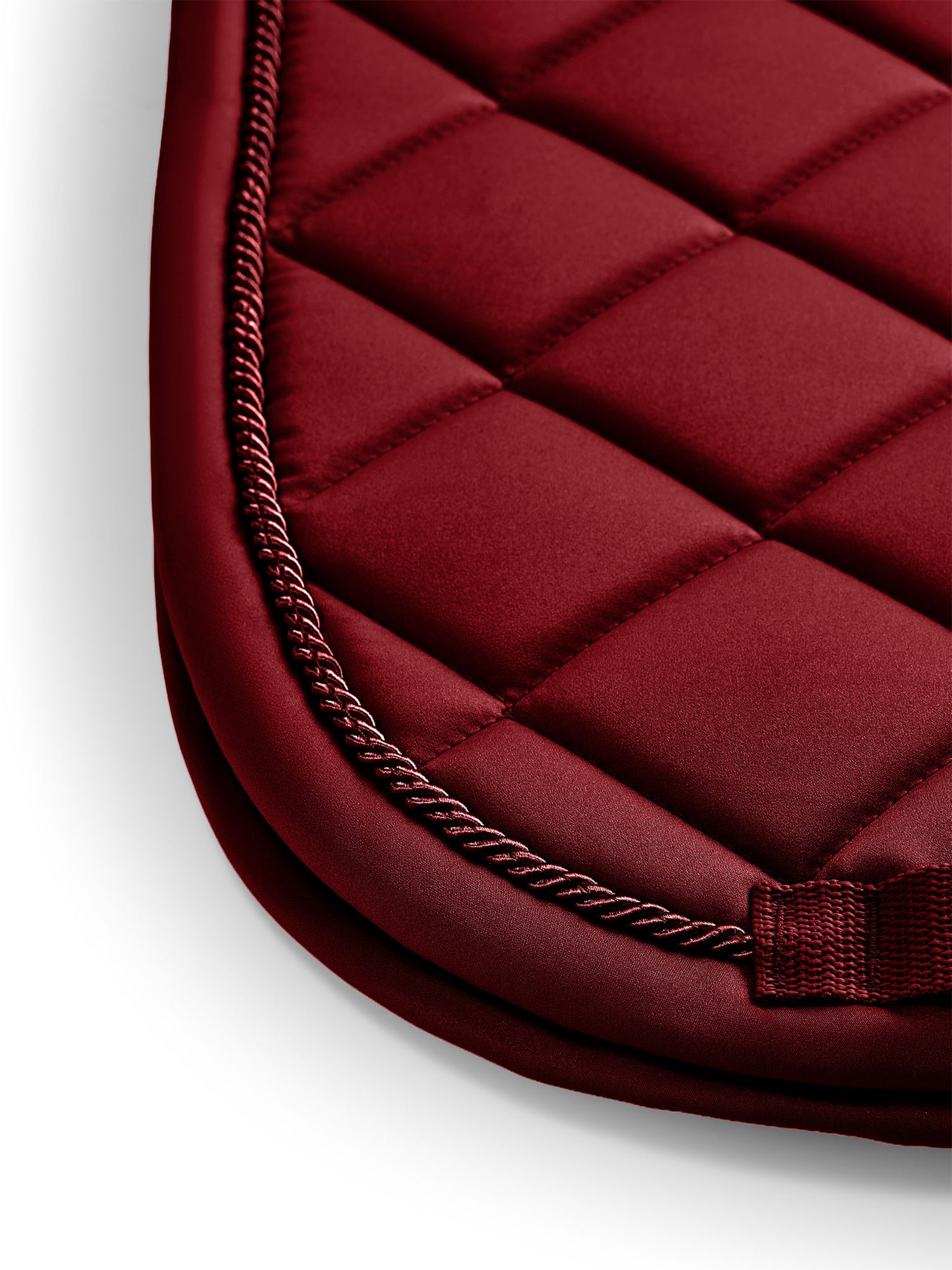 Studiobillede af Equestrian Stockholm Line Bordeaux sadelunderlag med dybrød quiltning og elegant snoet pibe.