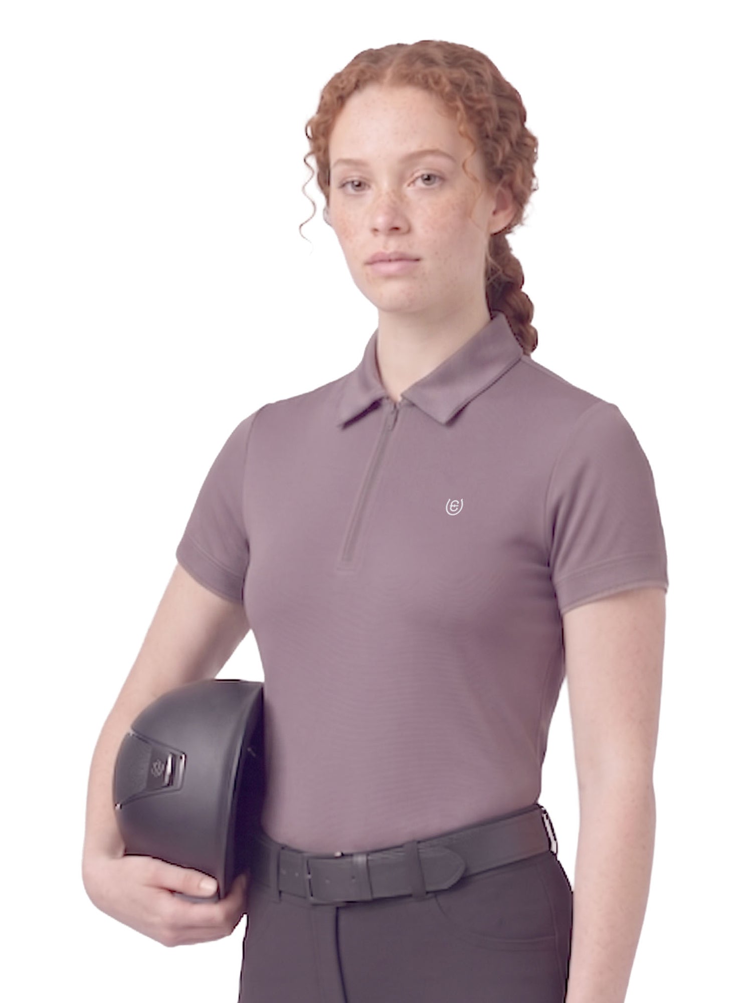 A model wearing the Equestrian Stockholm Short Sleeve Zip Top in Dusty Purple holding a black riding helmet.
