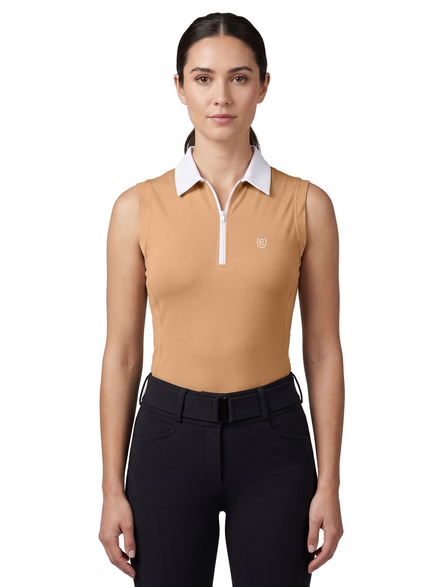 A model wearing Equestrian Stockholm Sleeveless Zip Top Savannah Glow in beige with white collar, black breeches, and belt.