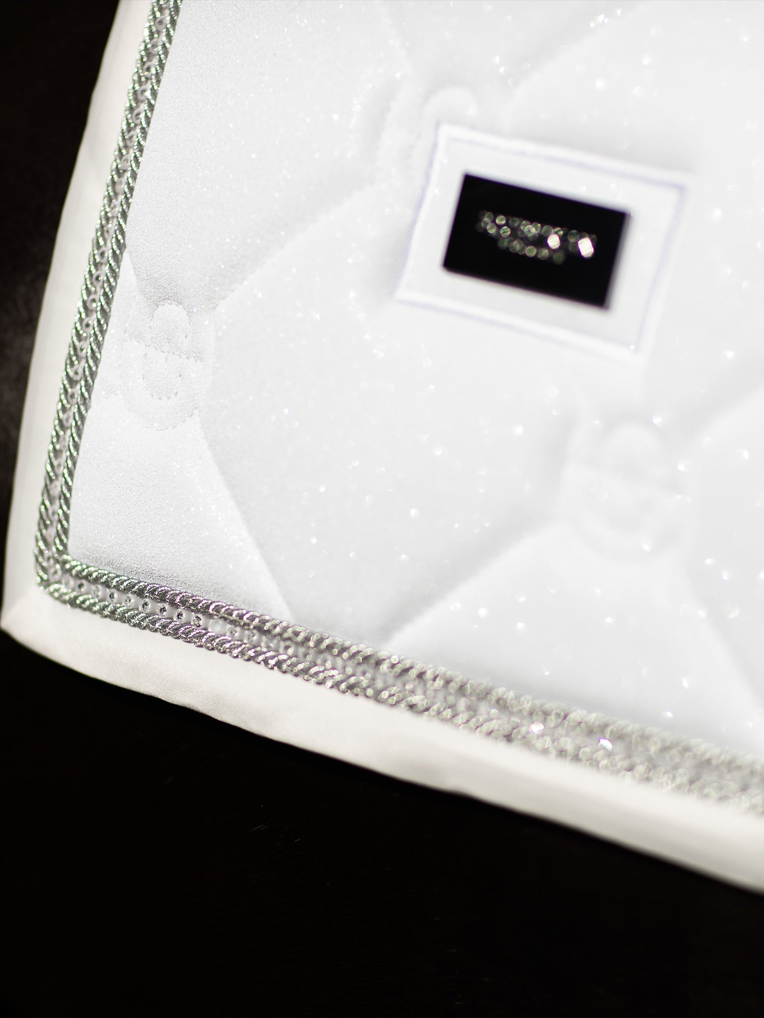 Studio image of Equestrian Stockholm Dressage Saddle Pad Crystal White Glimmer with silver crystal piping.