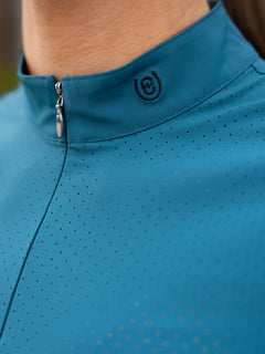 Studio image of Equestrian Stockholm Divine Motion Top Aurora Blues with perforated mesh and mock neck zip.