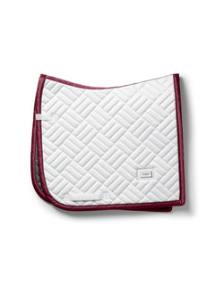 Image studio du tapis de dressage Equestrian Stockholm Modern White Merlot blanc, bordure merlot et insigne argenté.