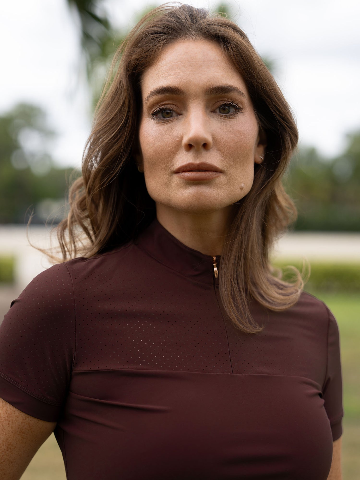 A model wearing the brown Equestrian Stockholm Divine Motion Top Endless Glow with laser-perforated detailing.