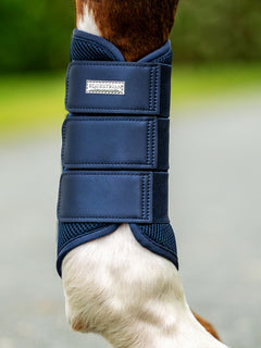 Studioaufnahme der Equestrian Stockholm Mesh Gamaschen Midnight Blue mit silbernem Abzeichen an einem Pferdebein.