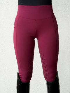 Studio image of Equestrian Stockholm Riding Tights Movement Merlot in dark red with a high waist and side pockets.