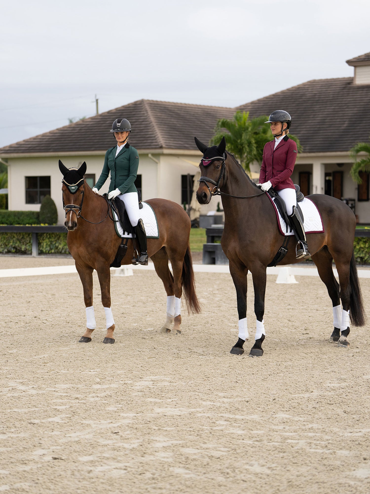 Cavaliers en vestes de concours Equestrian Stockholm Merlot et Sycamore Green, tapis de selle de dressage blancs et bonnets.
