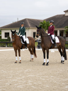Cavaliers en vestes de concours Equestrian Stockholm Merlot et Sycamore Green, tapis de selle de dressage blancs et bonnets.