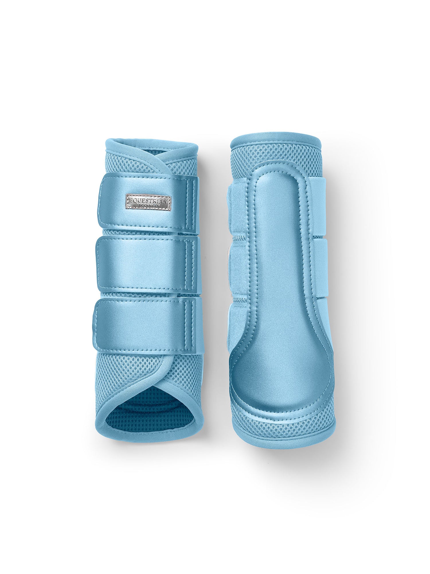 Studio image of Equestrian Stockholm Soft Blue Mesh Brushing Boots featuring breathable 3D mesh and silver badge.