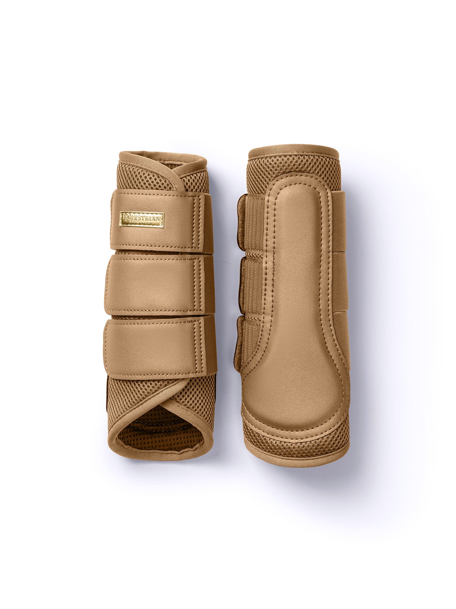 Studio image of Equestrian Stockholm Savannah Glow Mesh Brushing Boots in beige with breathable mesh and gold badge.