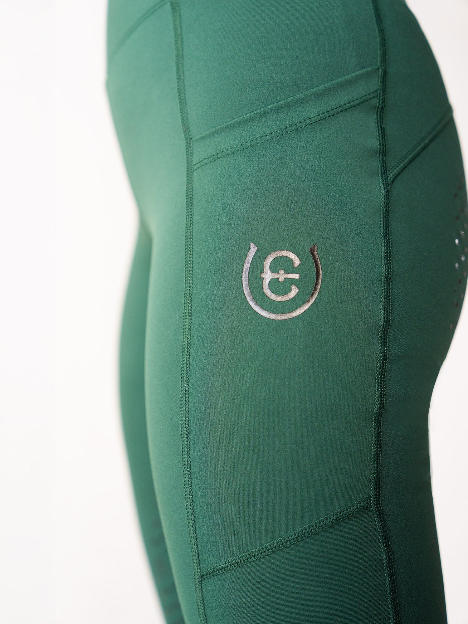 Studio image of Equestrian Stockholm Riding Tights Movement Sycamore Green with side pocket and logo detail.