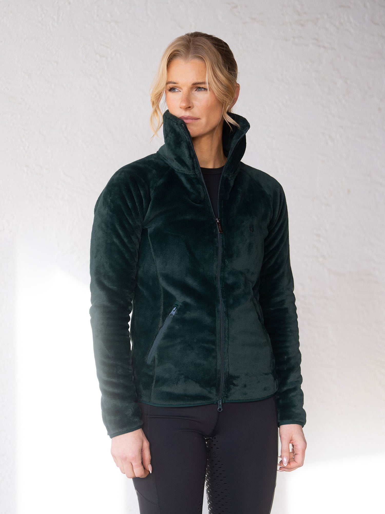 Mannequin portant la veste polaire Velvet Sycamore Green d’Equestrian Stockholm et un pantalon d’équitation noir.