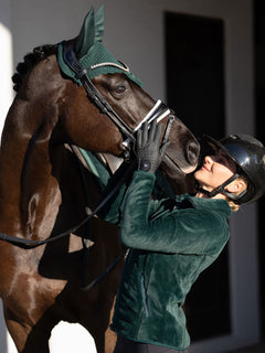Rider in Equestrian Stockholm Sycamore Green Velvet Fleece Jacket and horse wearing a matching velvet ear bonnet.