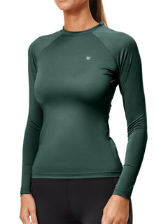 Studio image of Equestrian Stockholm Dynamic Base Layer Sycamore Green, a long-sleeve riding top and black breeches.