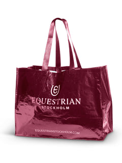 Image studio du sac d'écurie Merlot Equestrian Stockholm en tissu tissé rouge avec logo blanc et anses doubles brillantes.